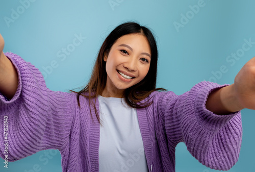 Photography concept. Portrait of asian woman taking selfie picture, point of view pov shot of smiling lady photo