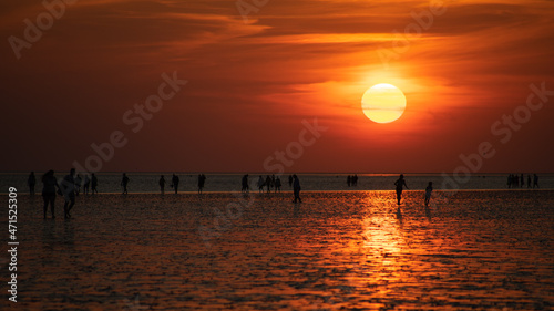 A group of people on the beach in the reflektion of the sunset off Buesum in the Wadden Sea. © Ralph