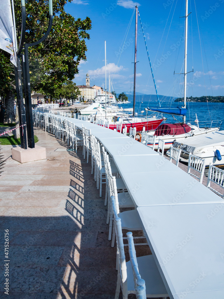 Long table for a dinner event at the edge of the Lake in Salò-Garda lake-Italy