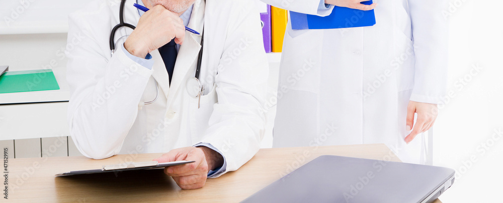doctor posing in office with medical staff, he is wearing a stethoscope doctor posing in office with medical staff, he is wearing a stethoscope