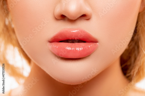 Sexy Lips. Part of Face, Young Woman close up. Perfect plump Lips bodily Lipstick. Peach Color of Lipstick on Large Lips. Perfect Makeup. Beautiful Lips Close-up. Makeup. Lip shiny Lipstick.        photo
