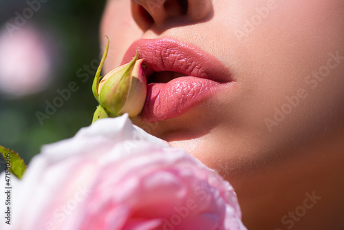 Sexy Lips. Beauty Red Lips Makeup Detail. Lips with spring flowers closeup. Beautiful woman lips with rose.