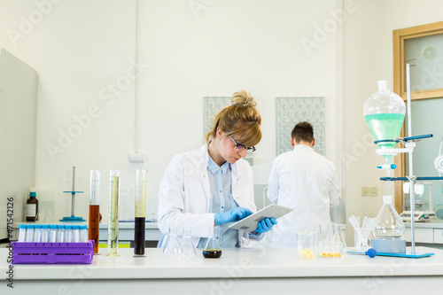 Scientist working on tablet in pharmaceutical laboratory