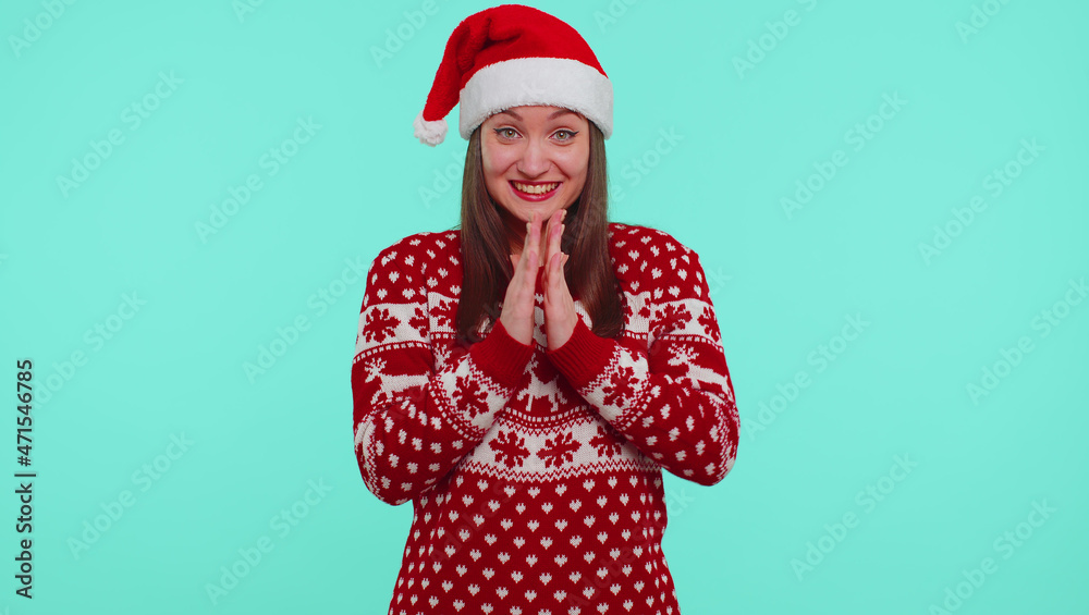 Girl 20s in red Christmas Santa sweater shouting, raising fists in gesture I did it, celebrating success, winning goal achievemen isolated on blue background studio. Happy New Year celebration party Girl 20s in red Christmas Santa sweater shouting, raising fists in gesture I did it, celebrating success, winning goal achievemen isolated on blue background studio. Happy New Year celebration party