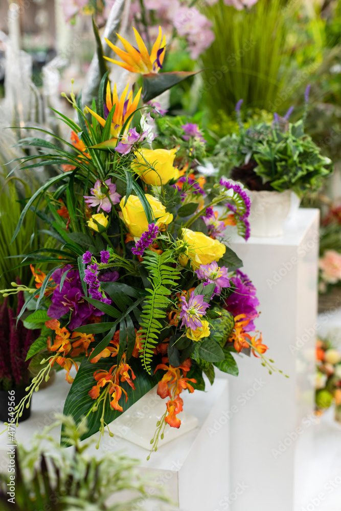 Fototapeta premium Floral interior decor, artificial bouquet of flowers yellow rose green fern on a white pedestal