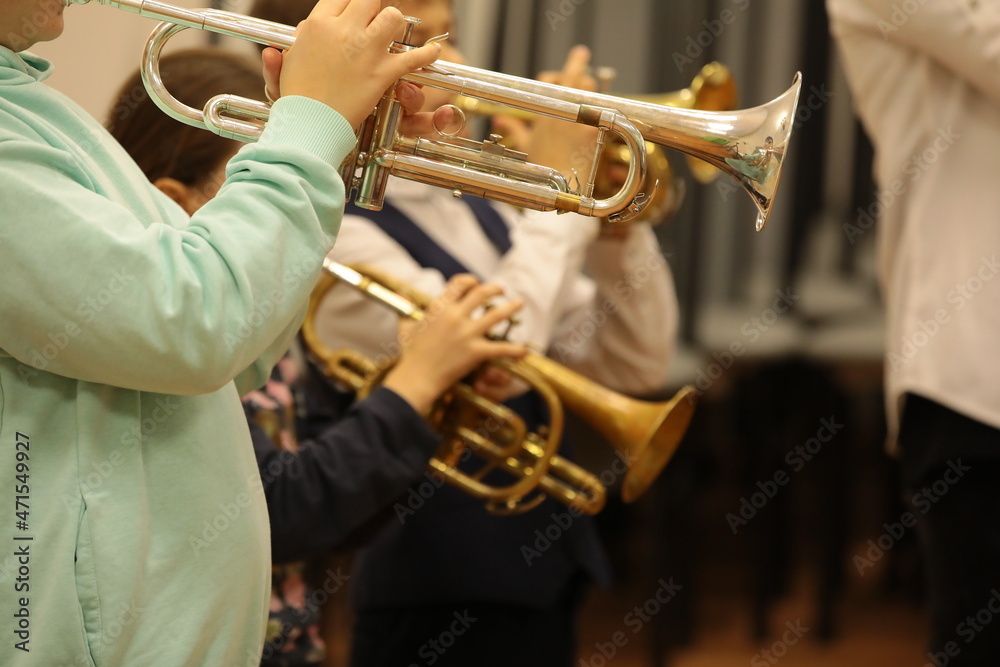 Fototapeta premium Group of children students of music college players young musicians standing playing a musical instrument trumpet at a jazz band class