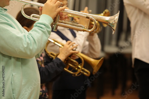 Group of children students of music college players young musicians standing playing a musical instrument trumpet at a jazz band class