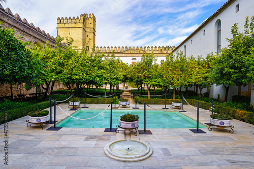 Patio with fountains and orange trees next to the wall of the Alcazar of Cordoba in Spain. photo
