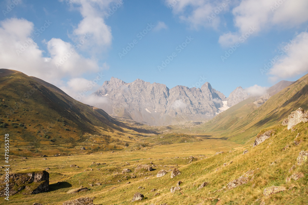 A panoramic view on the sharp mountain peaks of the Chaukhi massif in the Greater Caucasus Mountain Range in Georgia, Kazbegi Region. The valley is full of the Roshka stones. Georgian Dolomites.