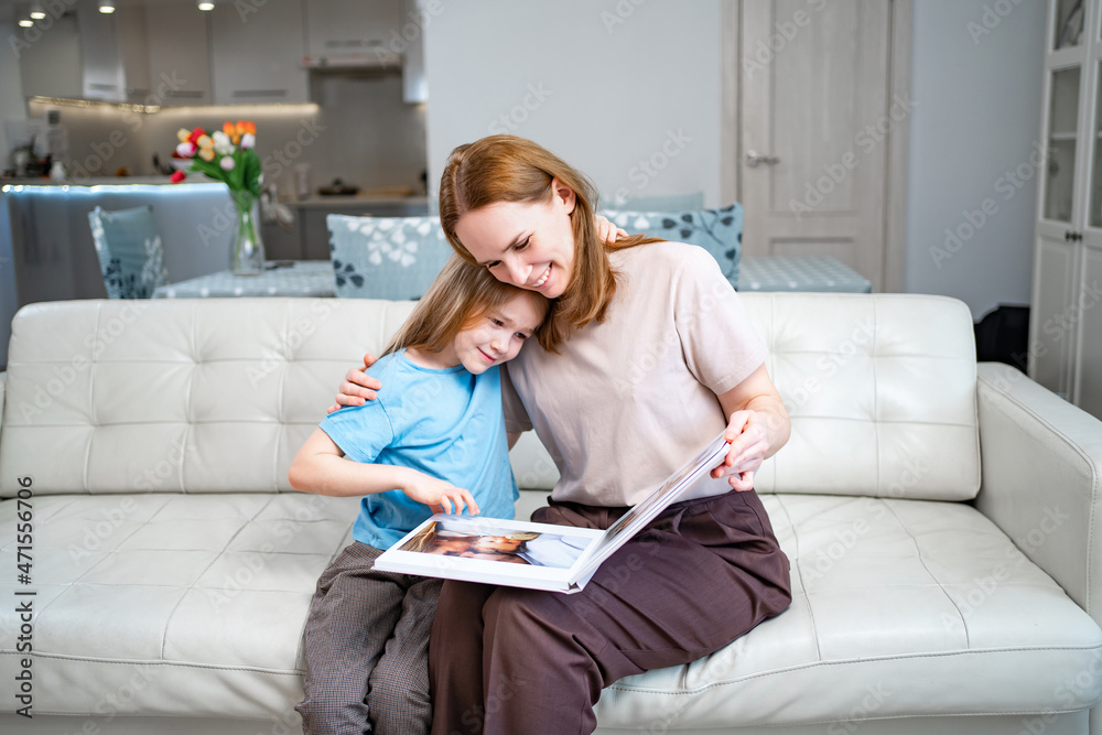 mother and daughter looking a book with photos from a family photo shoot mother and daughter looking a book with photos from a family photo shoot