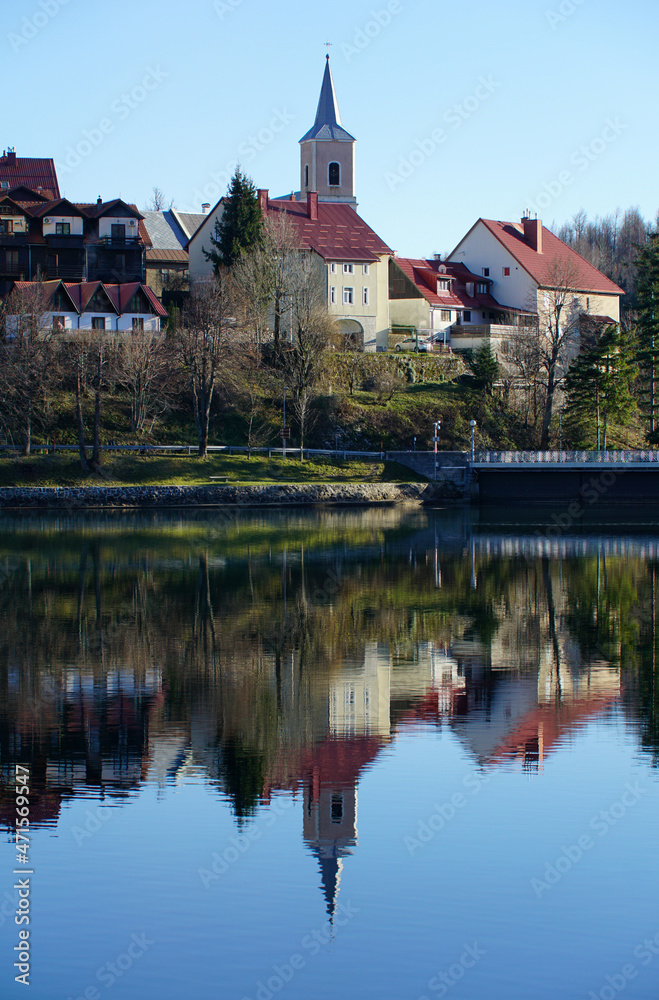 Church belfry reflection in the water at the beautiful autumn day