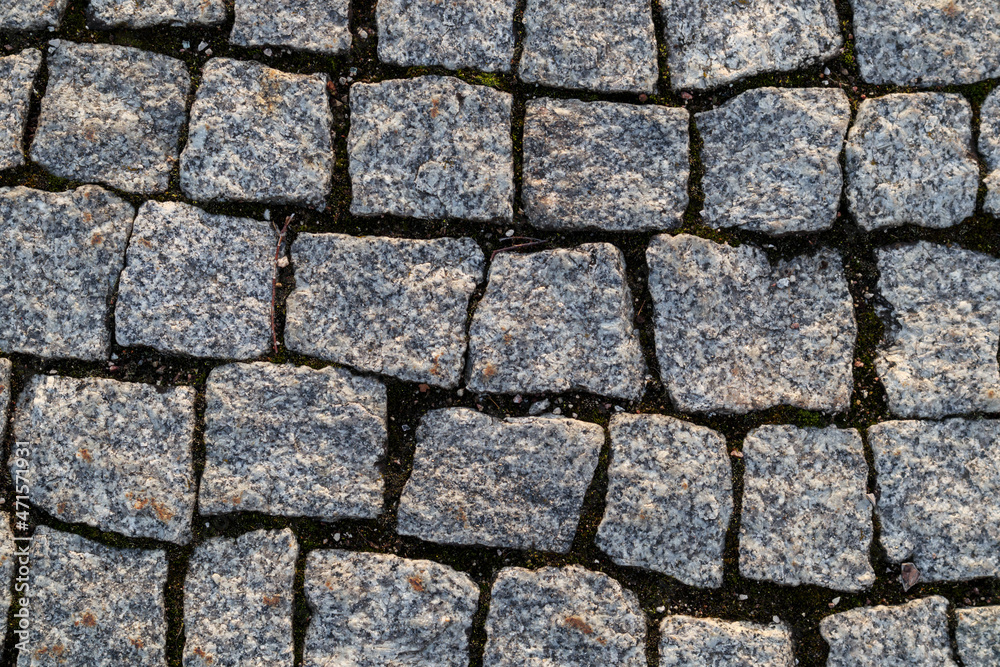 Cobblestone background from the sidewalk made of small stones Cobblestone background from the sidewalk made of small stones