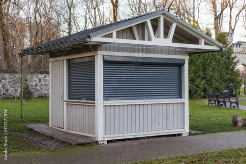Closed wooden kiosk in the park. The windows are closed with iron blinds © Armands photography