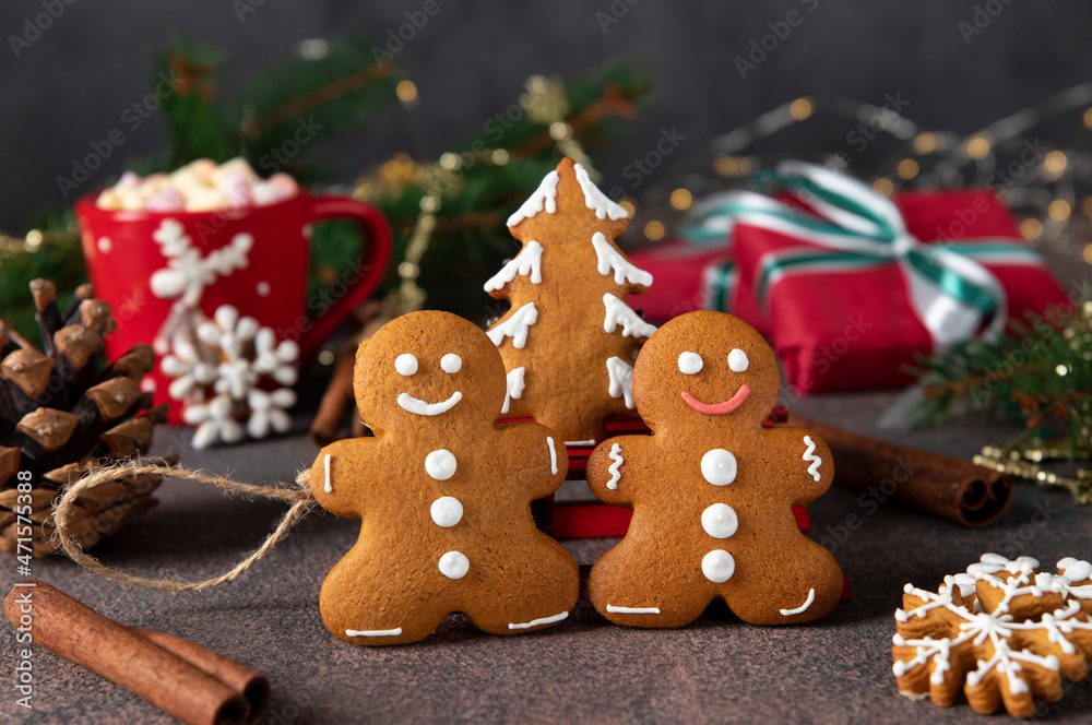 Gingerbreads man and christmas tree close up on festive new year background Gingerbreads man and christmas tree close up on festive new year background