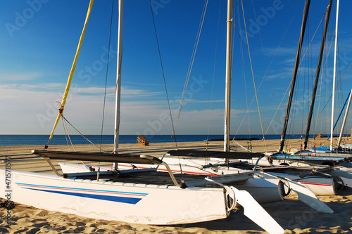 Catamarans rest along the shore on a sunny summer's day photo