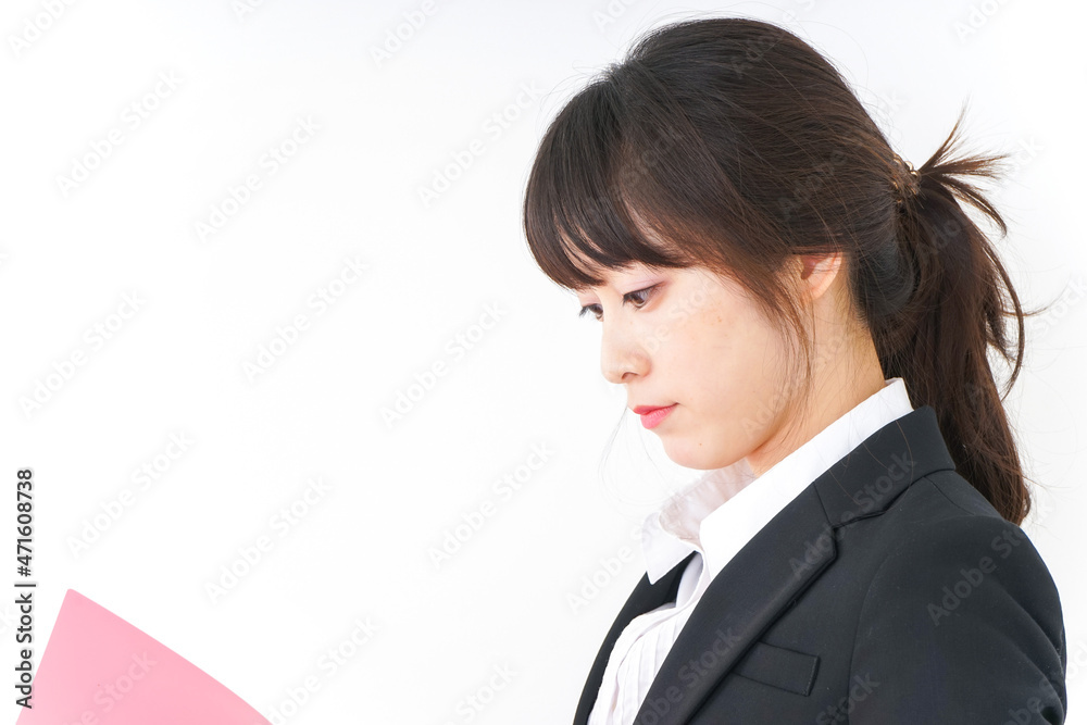 オフィスで書類を持つ若い女性 オフィスで書類を持つ若い女性