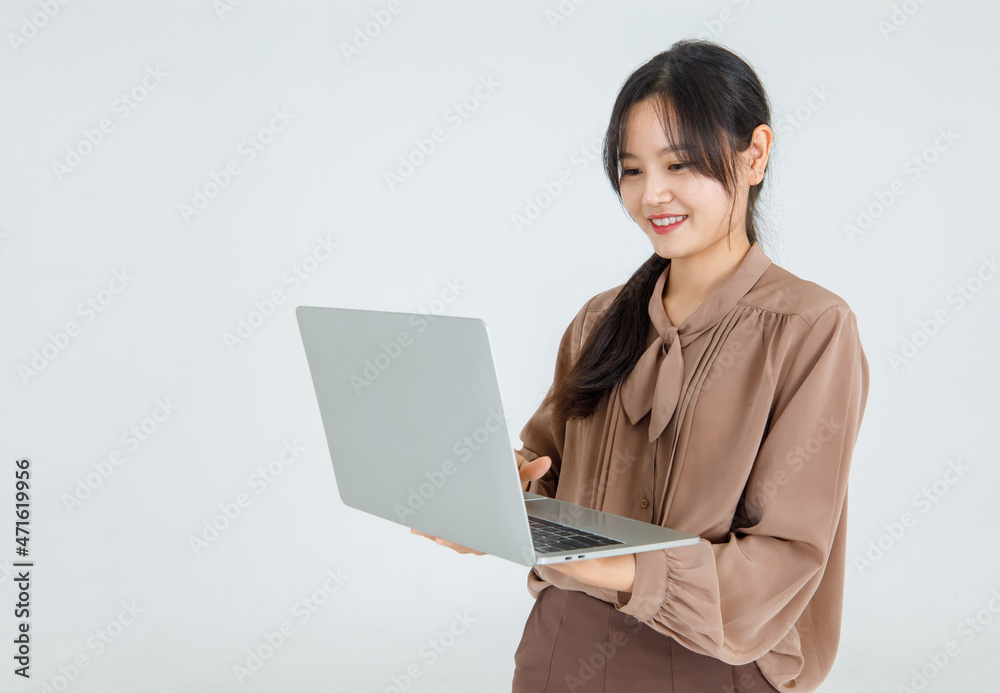 Pretty young Asian girl enjoy typing on laptop with smile and happy to carry it as comfortable handheld notebook for online communication and amusement Pretty young Asian girl enjoy typing on laptop with smile and happy to carry it as comfortable handheld notebook for online communication and amusement