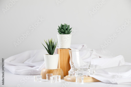 Gorgeous flower pot and empty drink glass on wooden tray with ice and cloth decoration on deluxe dining table for modern luxury spa and health care clinic
