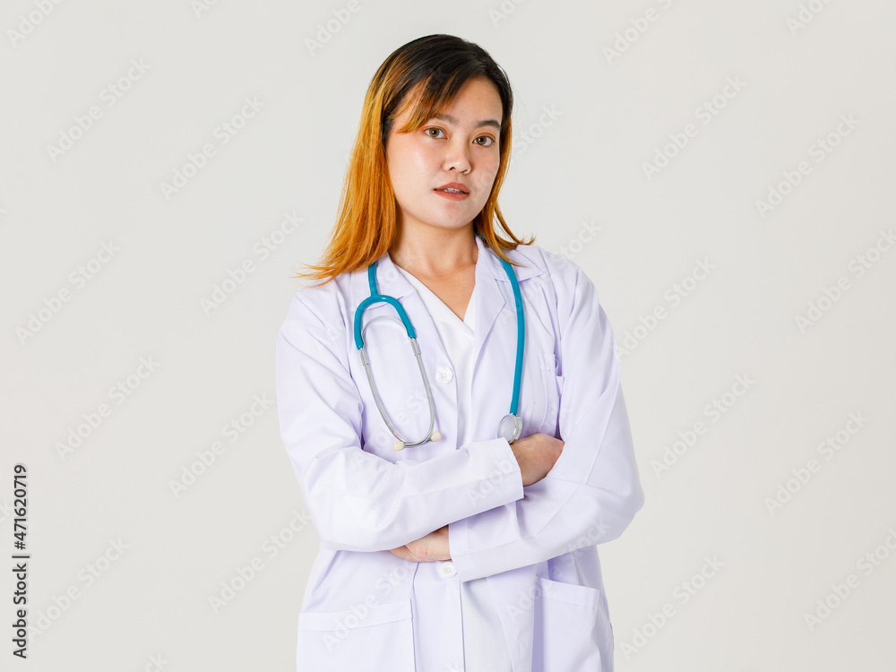 Portrait studio shot of Asian young successful professional confident dyed hair female doctor in lab coat hanging stethoscope around neck standing crossed arms look at camera on white background
