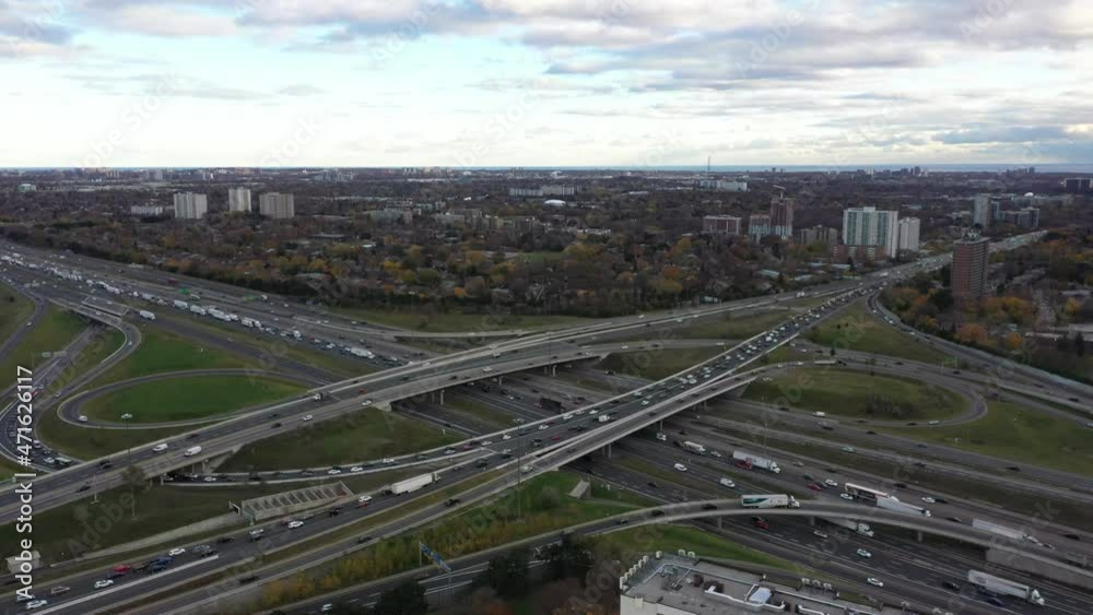 Drone view of the don valley parkway crossing the 40 highway constant traffic and fall colours with green grass green trees and yellow trees and brown trees not colour graded Drone view of the don valley parkway crossing the 40 highway constant traffic and fall colours with green grass green trees and yellow trees and brown trees not colour graded