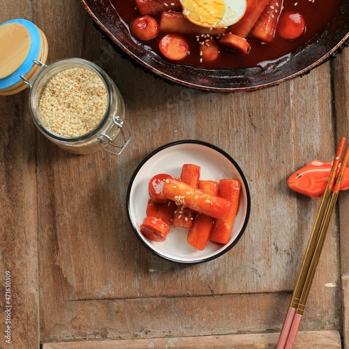 Topokki or Tteokbokki is Stir-fried Rice Cake with Vegetables and Fish Cake in Spicy Sauce Top with Sesame Seed, Famous and Popular Korean Street Food photo