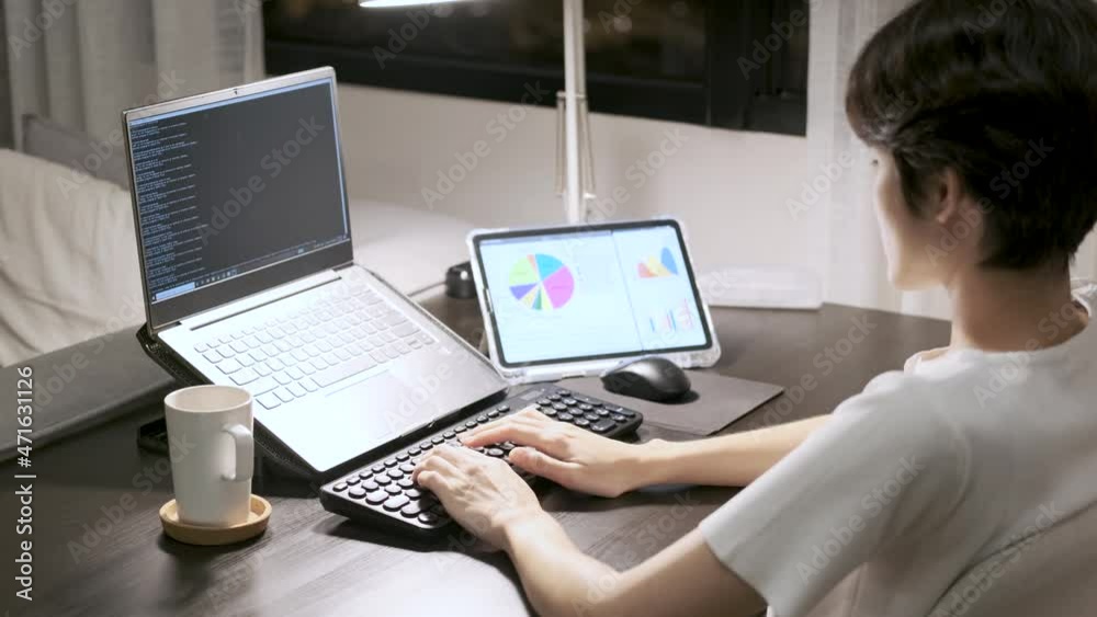 side view asian female is typing the code on the keyboard for an ongoing big project in the late night at home with coffee cup and tablet on desk 4k side view asian female is typing the code on the keyboard for an ongoing big project in the late night at home with coffee cup and tablet on desk 4k