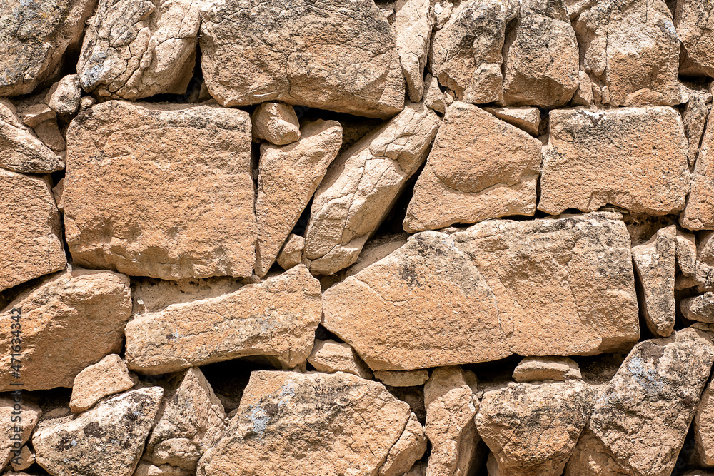 Fototapeta premium Stone wall texture - brown stone siding with stones of different sizes