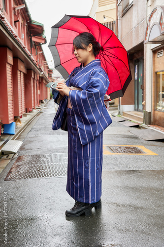 傘を持って東京の下町を歩く着物姿の日本人女性 © photok