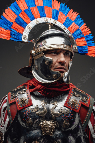 Roman centurion wearing steel armor against dark background