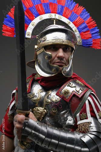 Fotografia Combative roman centurion dressed in armor holding gladius