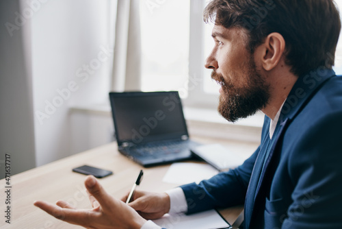 manager sitting at a desk in front of a laptop finance network professional