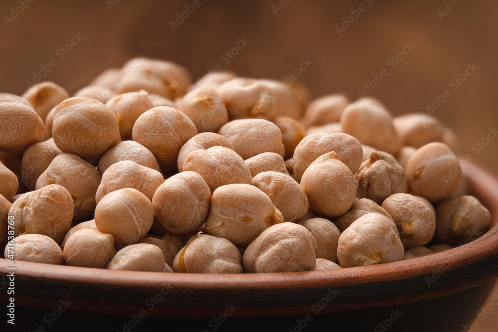 Raw uncooked chickpea beans in a bowl close-up