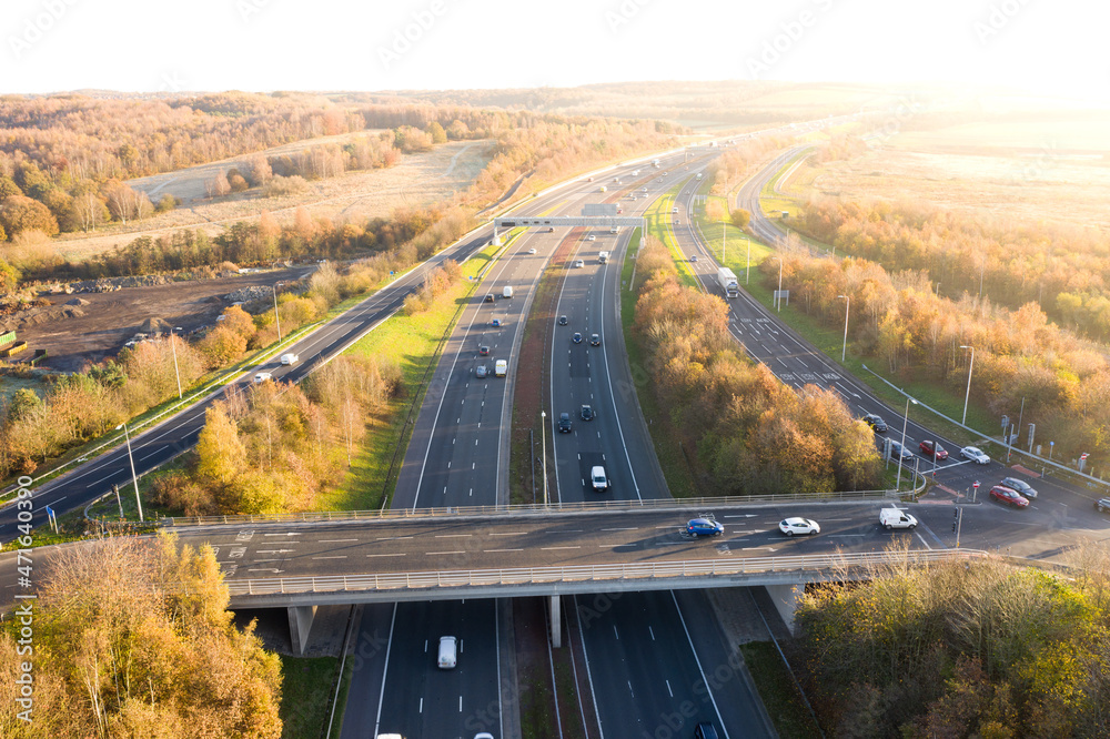 Aerial view of UK motorway and overbridge at sunset - obrazy, fototapety, plakaty 