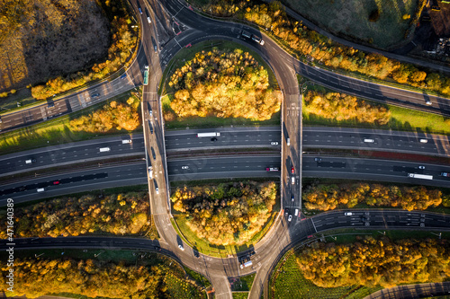 Aerial view directly above a busy UK motorway with overpass roundabout junction
