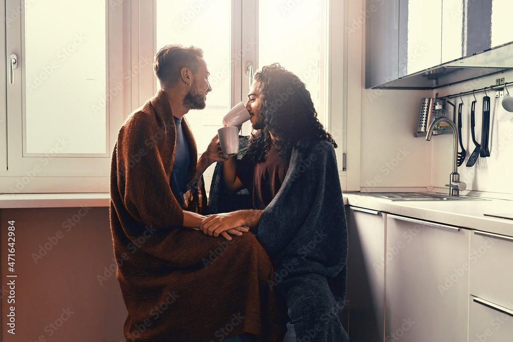 A gay male couple drinks milk in the morning. Two homosexuals hug each other under a blanket. - obrazy, fototapety, plakaty 