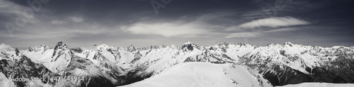 Black and white panorama of high snow-capped mountain peaks at winter