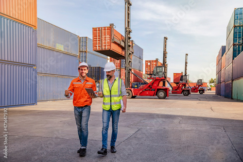 Engineer male worker holding tablet working logistic cargo container inside factory
