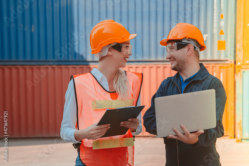 A male engineer with a laptop and a female engineer inspecting a logistic cargo container 