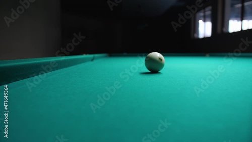 Wallpaper Mural Lone billiard ball with the number three, slowly rolling across the green baize table in a dark gloomy room. Concept of games and entertainment. Torontodigital.ca