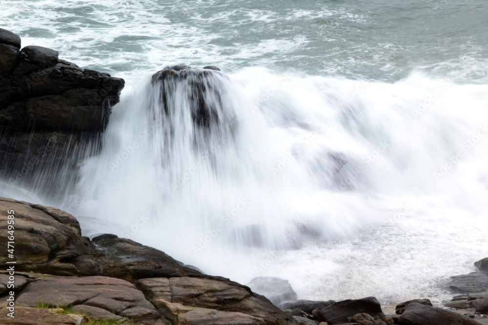 sri lanka, water breaks on rocks in the indian ocean