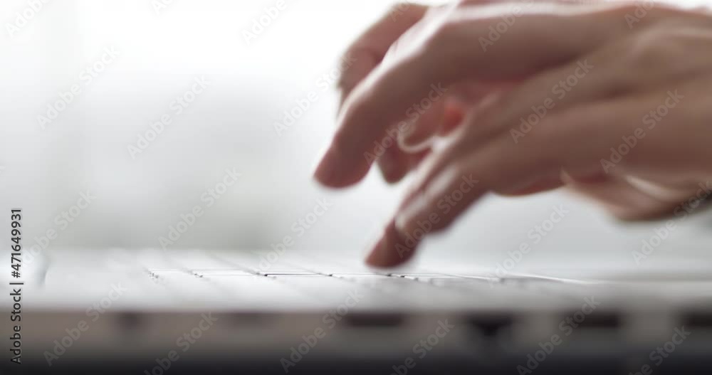 Female fingers are typing text on the laptop keyboard. Business woman works using a computer. Close-up.
