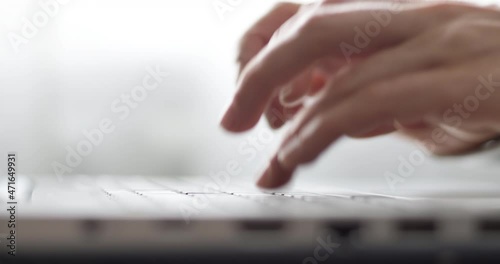 Female fingers are typing text on the laptop keyboard. Business woman works using a computer. Close-up.