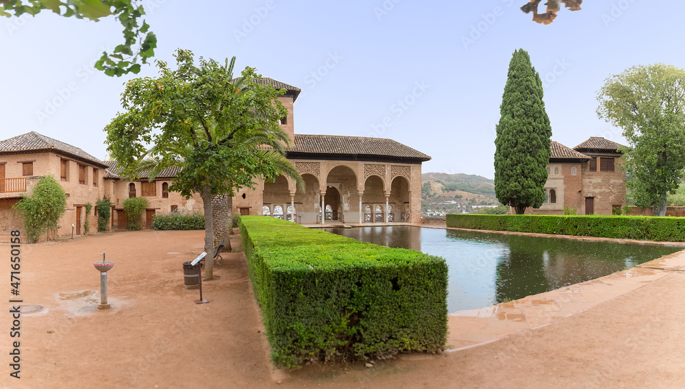 View at the Partal Palace or Palacio del Partal , a palatial structure around gardens and water lake inside the Alhambra fortress complex located in Granada, Spain