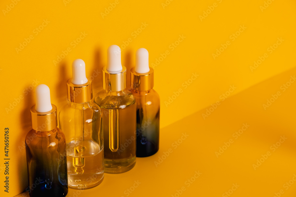 Naklejka premium Dropper glass bottles with pipette. Transparent hyaluronic natural beauty mineral product and eco serum skin care concept. Top horizontal view copyspace. Summer juicy colors.