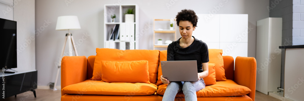 Happy Young African Woman Using Laptop Sitting On Couch Happy Young African Woman Using Laptop Sitting On Couch