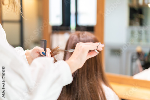 女性のヘアカットをする美容師