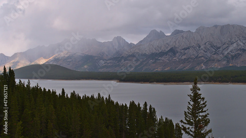 Beautiful panoramic view of Lower Kananaskis Lake in Alberta, Canada in the Rocky Mountains on cloudy day in autumn season with coniferous forest.
