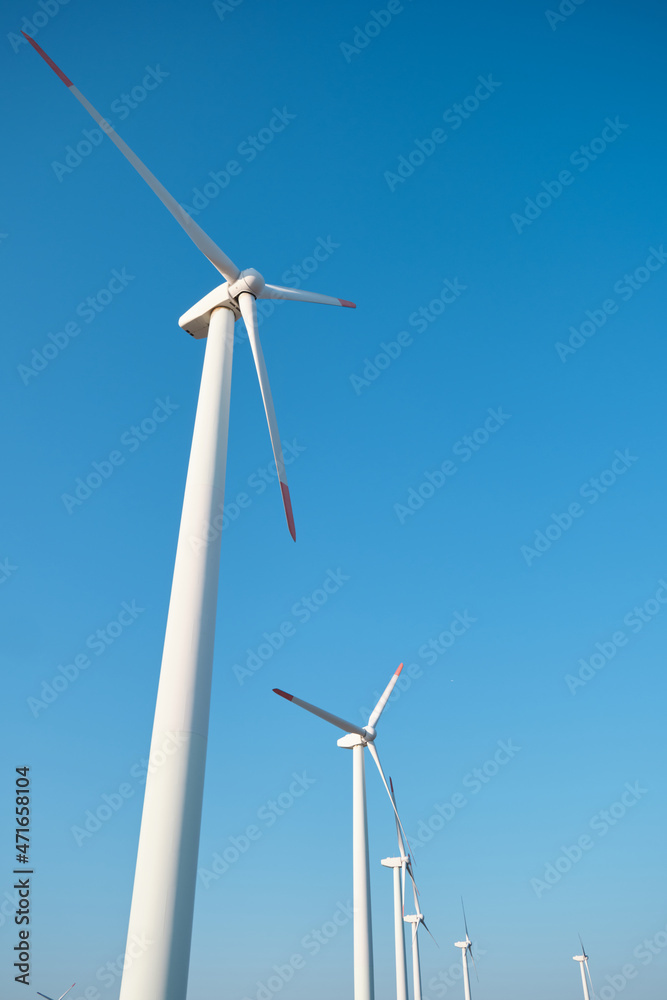 Wind turbines producing green renewable energy on a blue sky Wind turbines producing green renewable energy on a blue sky