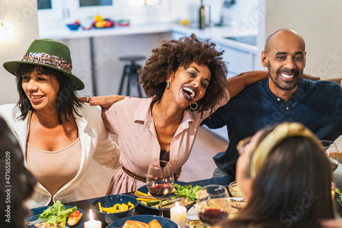 Фотография Multicultural party of adult friends gathered for dinner is having fun