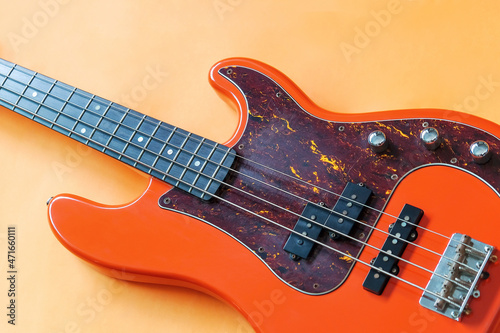 orange electric bass guitar on orange background with copy space photo